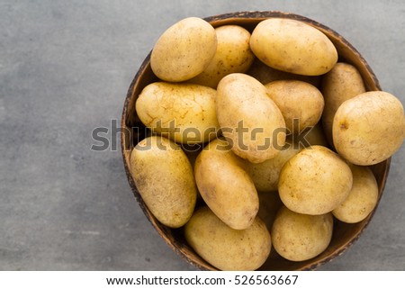Potato on the bowl, gray background.