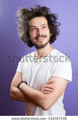 Beautiful caucasian man with funny hair over color background