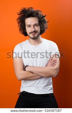 Beautiful caucasian man with funny hair over color background