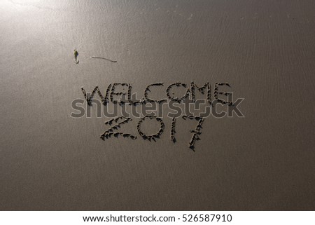 "Welcome 2017," written in the sand with a view of the ocean.Image has grain or blurry or noise and soft focus when view at full resolution