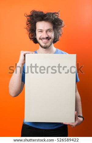 Bearded man with mustache and funny hair holding blank white board on orange  background
