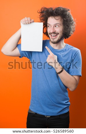 Bearded man with mustache and funny hair holding blank white board on orange  background