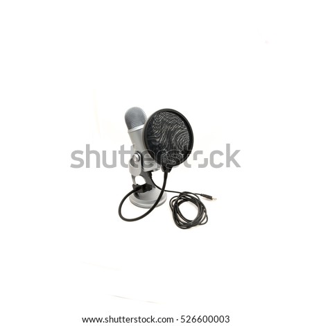Close up pop filter attached to microphone with USB cable isolated on white background. Modern space grey USB microphone with recording control buttons for podcast, broadcasting or voice over works.