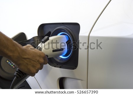Plug the charger Access to vehicle electrification. Royalty-Free Stock Photo #526657390