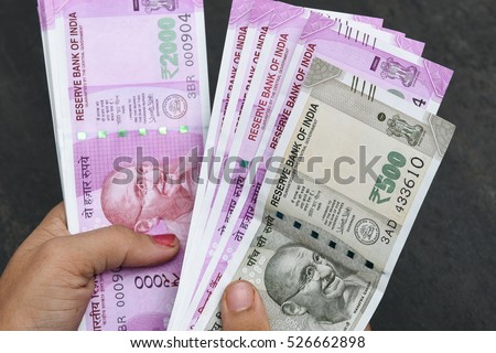 2000 and 500 rupee banknote India,The brand new Indian currency notes of 2000 and 500 rupees isolated on black. Business woman holding counting money. Success and got profit from business Royalty-Free Stock Photo #526662898