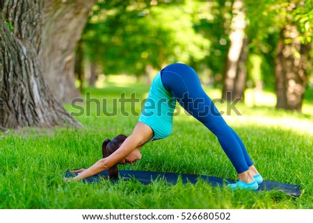 Yoga woman on green grass girl relaxing in a field. Yoga woman on green park girl doing gymnastics outdoors. Meditating woman in meditation in yoga pose practicing outdoors.