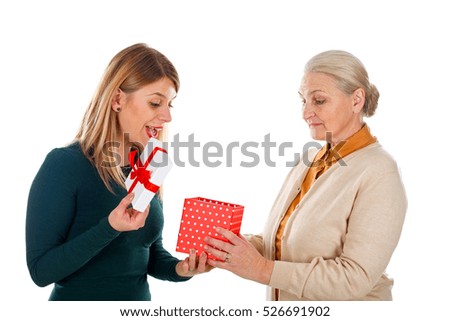 Picture of a happy young woman receiving a Christmas gift from her mother