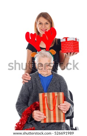 Picture of an old lady receiving Christmas gifts from her granddaughter