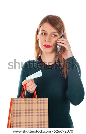 Picture of a happy young woman on the phone while doing Christmas-shopping