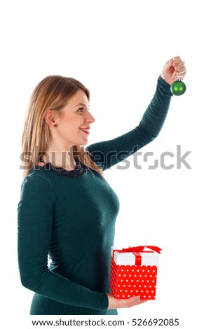 Picture of a beautiful young woman holding Christmas gift and decoration