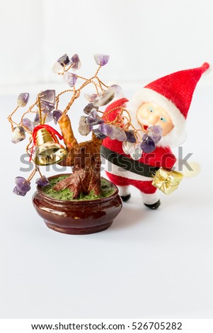 Santa Claus with a gift in hand and a Christmas tree with leaves of amethyst