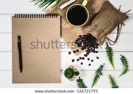 White designer wooden desk with coffee cup and coffee bean, top view photography, flat lay display.