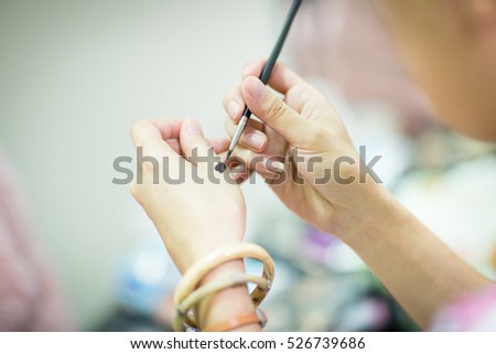 professional make-up artist   testing foundation on hand isolated on white background. Creative makeup artist. Make up artist. make-up artist on the wedding day.blur image of people at haircut shop.