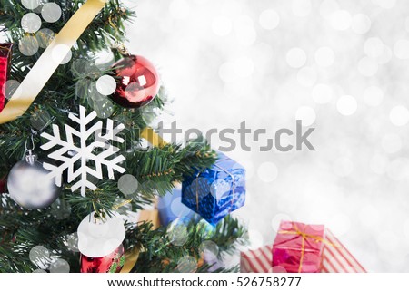 Christmas decorative with gift box and snowflake on christmas tree and bokeh light background.