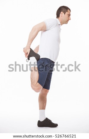 Young man stretching legs befor training, white background