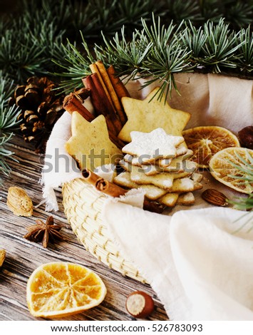Christmas or new year gingerbread cookies in a Jewish star in a wooden box with cinnamon, almonds, dried slices apelchina and spruce twigs on rustic table, selective focus