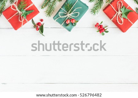 Christmas border. Christmas gifts, fir branches on wooden white background. Flat lay, top view, copy space