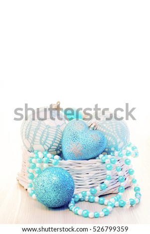 Blue Chritmas balls decorated with knitted pattern and blue-white beads in basket with white copy space
