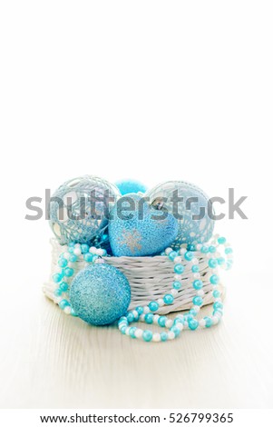 Blue Chritmas balls and blue-white beads in basket with white copy space