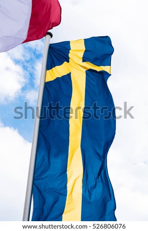 Swedish country flag arranged against a blue sky.