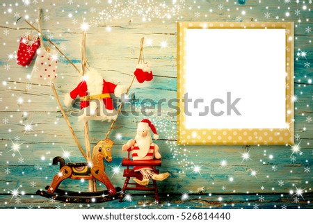 Christmas photo frame card, Santa Claus rag doll, cute tree and rocking horse with empty photo frame, vintage tone wooden background