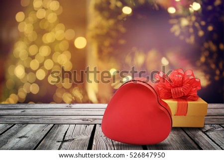 Christmas Gift box and red heart on wooden table with christmas light night,abstract circular bokeh background