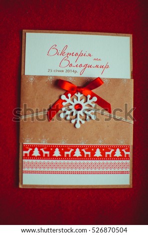 Wedding invitation letter decorated with red ribbon and little snowflake