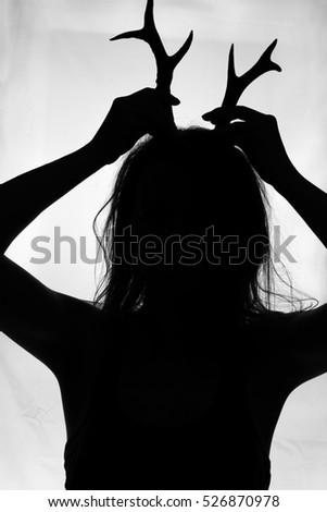 Woman horns silhouette. Black and white photography. Cheating concept. Halloween. Mythical woman with antlers. Mysterious woman female. Shaman.  Woman from a fairy tale with horns. Witch silhouette.