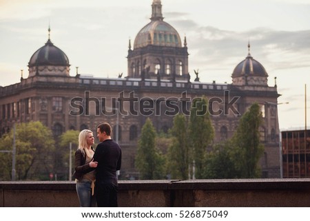 beautiful and young couple standing on the background of a large building