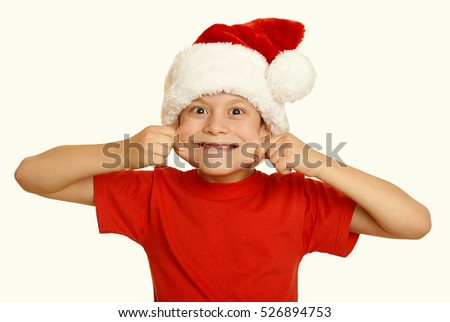 boy child make faces in santa hat, having fun and emotions, winter holiday concept, yellow toned