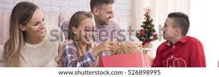 Happy family spending christmas morning opening the gifts