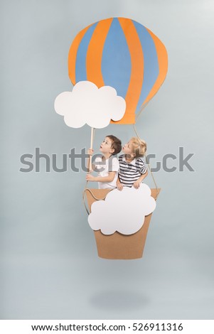 Children sitting in diy paper balloon basket