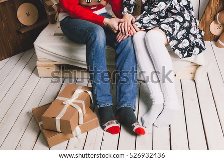 young beautiful couple gives each other gifts and celebrate Christmas Merry Christmas, celebrate the new year, the house is tree and fireplace, sit together and enjoy each love, hipster  style, cute