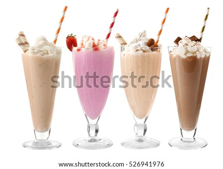 Glasses with delicious milk shakes on white background. Royalty-Free Stock Photo #526941976
