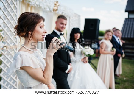 Master of ceremony speech on microphone background wedding couple. Royalty-Free Stock Photo #526970929