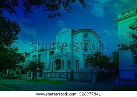 Architectural buildings along the Alster canal in Hamburg German.Luxury old mansions in Winterhude neighborhood against sky, image with blue color filter for real estate agent business, realtor blog