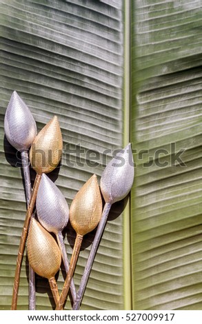 Gold and silver water lily in banana leaf,abstract background