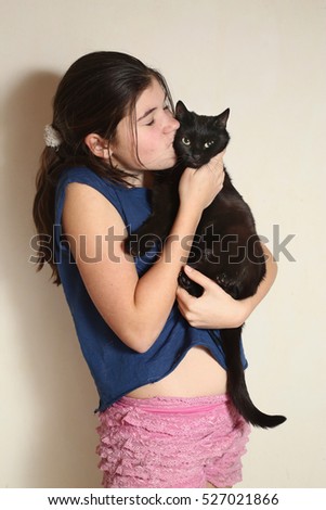 teen girl kissing black cat 