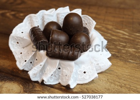 Chocolate candy in basket on wooden board