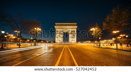 The Arc de Triomphe de l'Etoile (Triumphal Arch of the Star) at Night. It is one of the most famous monuments in Paris, standing at the western end of the Champs-Elyseees.  Royalty-Free Stock Photo #527042452