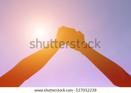 A young couple holding hands. In Nature sunrise