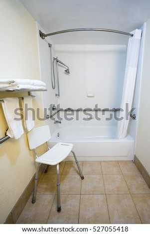 Hotel Handicap Bathroom with a Chair and Shower Bathtub Handrails