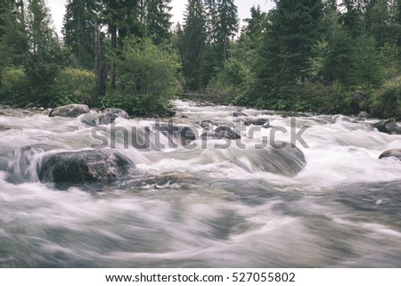 mountain river in summer with stream and high water in forest- vintage retro look