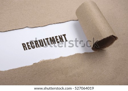 Torn brown paper on white surface with "recruitment" word. Business concept