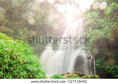 The nice water fall in the highest mountain in Thailand by soft movement by slow shutter speed and flare and water splatter on the camera lens.