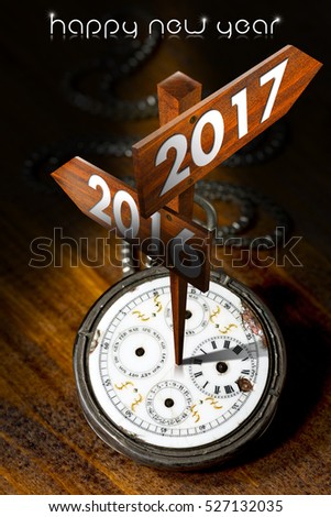 Happy New Year 2017 - Old pocket watch with two wooden signs with arrows and the years 2016 and 2017