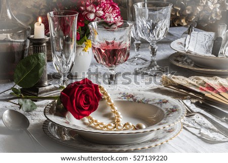 romantic evening / table prepared for a special lunch with jewelry and rose, romantic atmosphere, front view, effect white vignetting