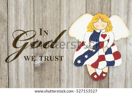 America patriotic message, USA patriotic old flag on an angel and weathered wood background with text In God we Trust