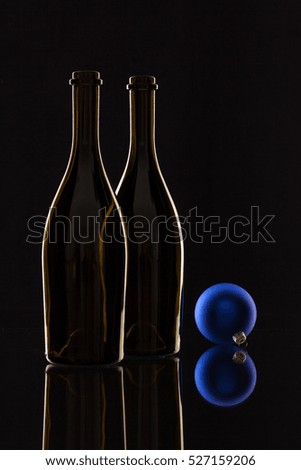 Silhouette of elegant wine bottles and Christmas decoration on a glass table