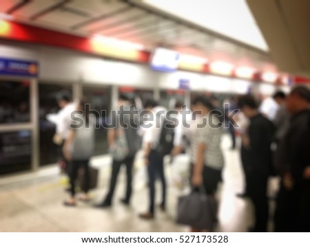 Blurred image of people waiting for subway at station, transportation background with vintage tone.